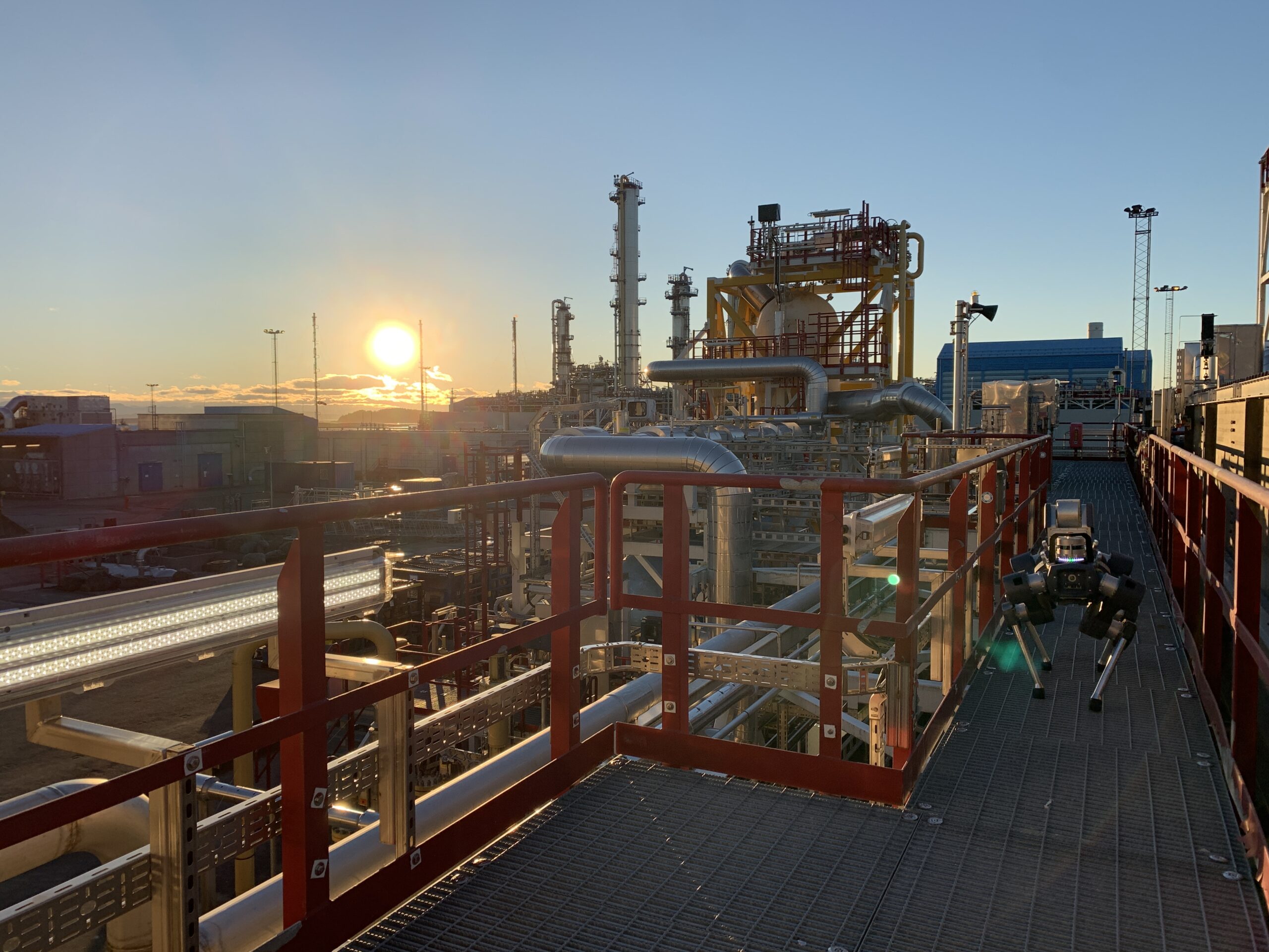 ANYmal X on a mission during sunset at a facility at Equinor